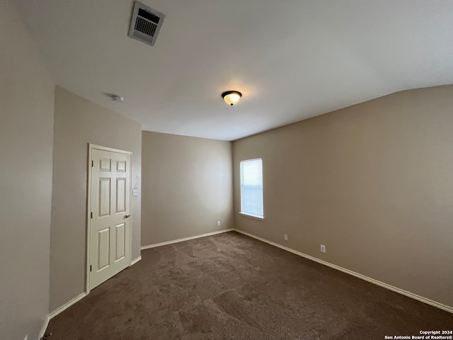 unfurnished room featuring dark colored carpet