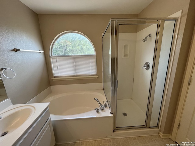 bathroom with a stall shower, vanity, and a bath