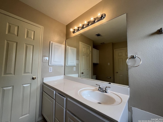 bathroom featuring a textured wall and vanity