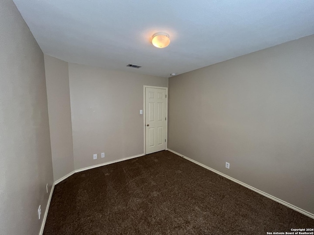 unfurnished room featuring carpet floors, visible vents, and baseboards