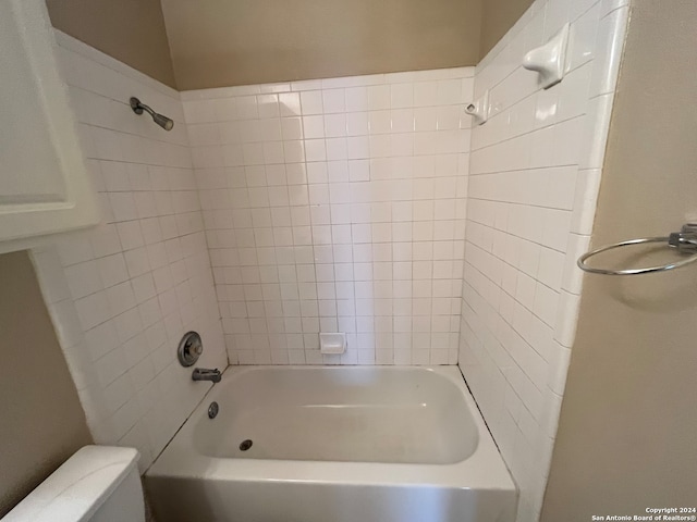 bathroom featuring tiled shower / bath and toilet