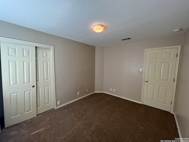 unfurnished bedroom with dark carpet