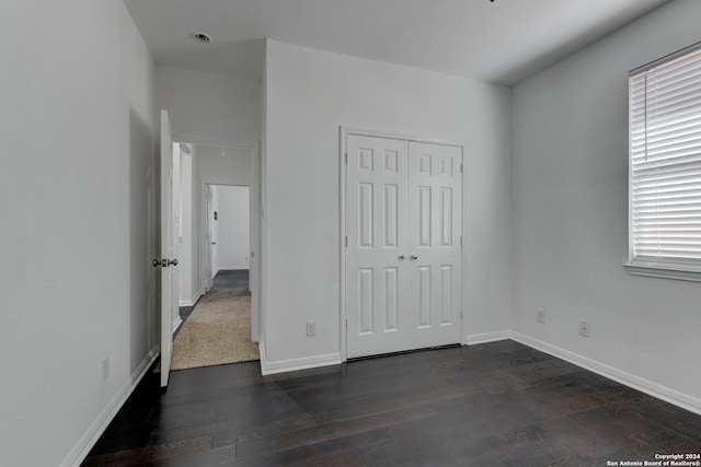 unfurnished bedroom featuring dark hardwood / wood-style floors and a closet