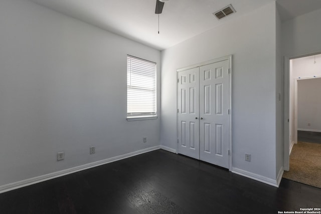 unfurnished bedroom featuring a closet, dark hardwood / wood-style floors, and ceiling fan