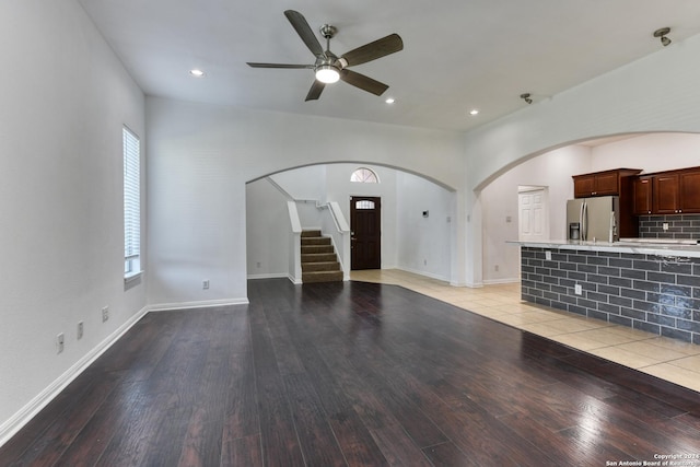 unfurnished living room featuring ceiling fan and light wood-type flooring