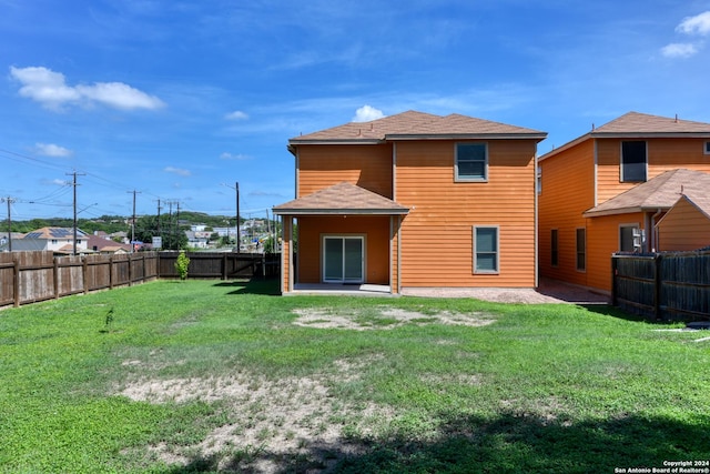 rear view of property featuring a lawn