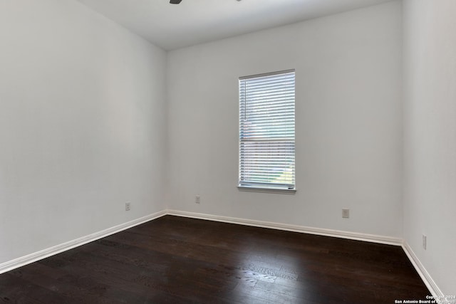 empty room featuring dark wood-type flooring and ceiling fan