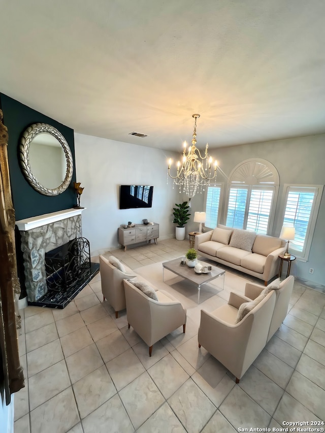 living area with light tile patterned floors, visible vents, a fireplace, and an inviting chandelier