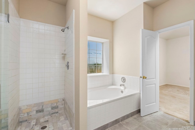 bathroom with a shower stall, a bath, and tile patterned floors