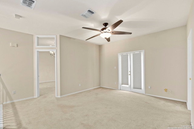 empty room with a ceiling fan, visible vents, light carpet, and baseboards