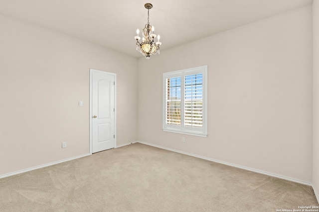 unfurnished room with light carpet, an inviting chandelier, and baseboards