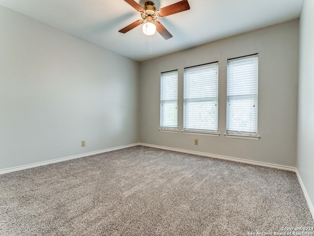 spare room with carpet, baseboards, and a ceiling fan