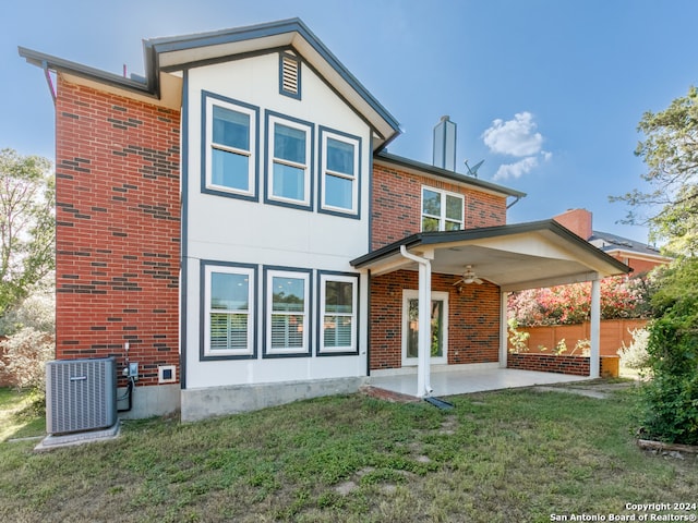 rear view of property with a ceiling fan, a patio, a yard, central air condition unit, and brick siding