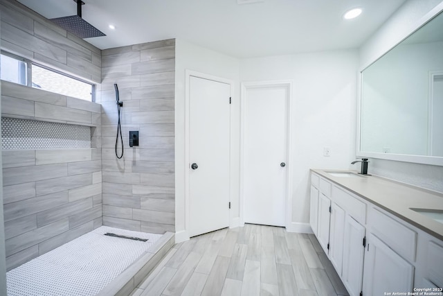 bathroom with vanity and a tile shower