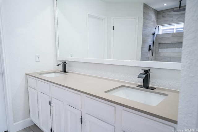 bathroom featuring tiled shower and vanity