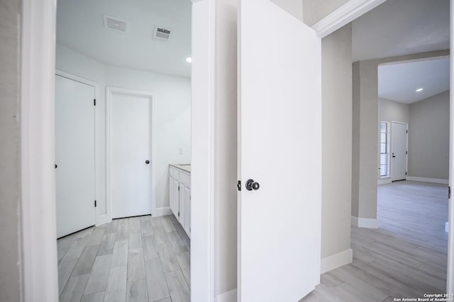 corridor with light hardwood / wood-style flooring