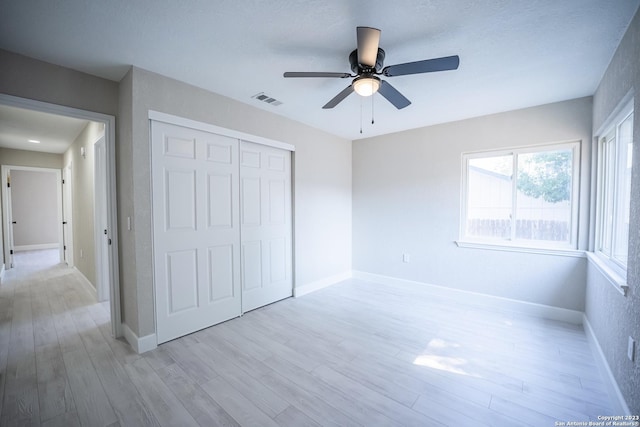 unfurnished bedroom with ceiling fan, a closet, and light hardwood / wood-style flooring