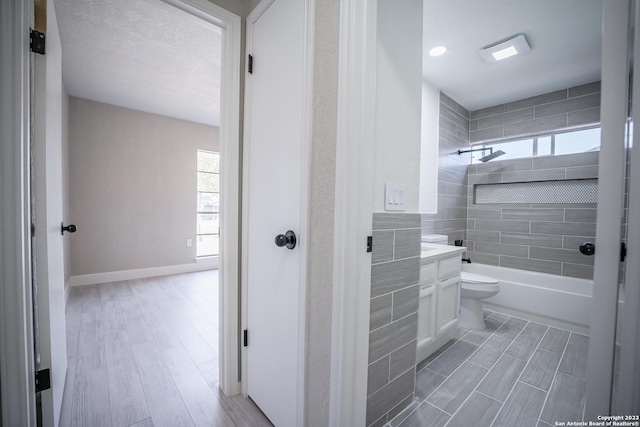 full bathroom with vanity, tiled shower / bath, and toilet