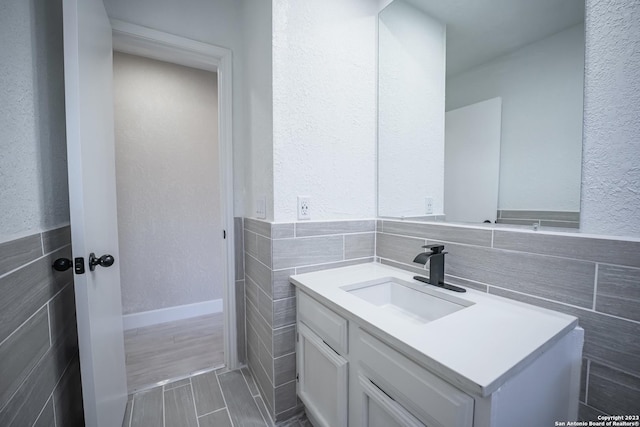 bathroom featuring vanity and tile walls