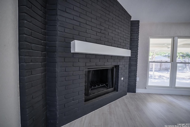 room details with a brick fireplace and wood-type flooring