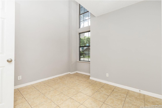 spare room featuring light tile patterned floors and plenty of natural light