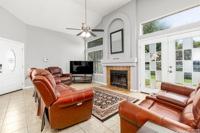 living room with french doors, high vaulted ceiling, light tile patterned floors, ceiling fan, and a fireplace