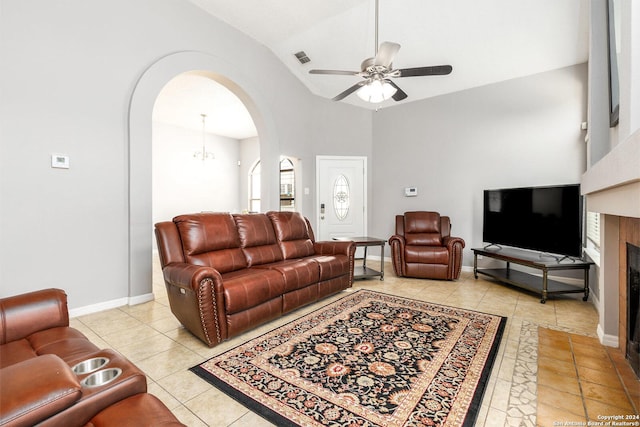 tiled living room with vaulted ceiling and ceiling fan with notable chandelier