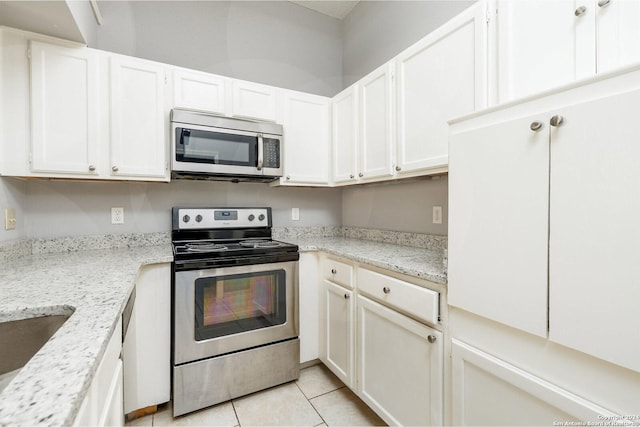 kitchen featuring white cabinetry, light tile patterned floors, light stone counters, and stainless steel appliances