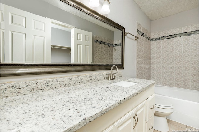 full bathroom with tiled shower / bath combo, vanity, a textured ceiling, tile patterned floors, and toilet