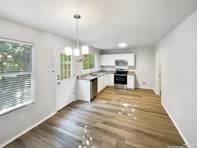 kitchen with sink, white cabinetry, hanging light fixtures, stainless steel appliances, and light hardwood / wood-style floors