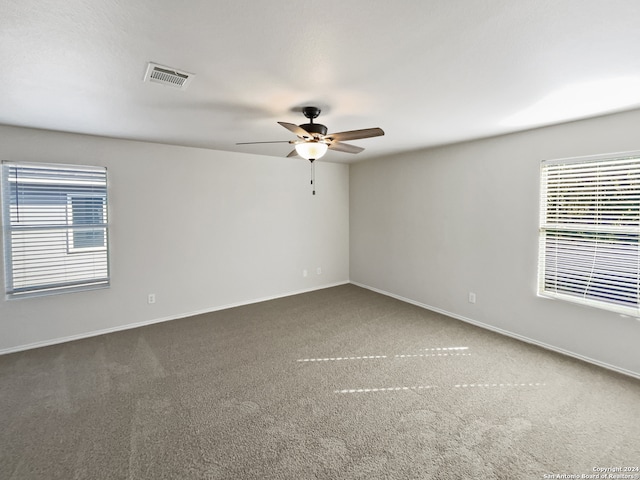 carpeted spare room with ceiling fan