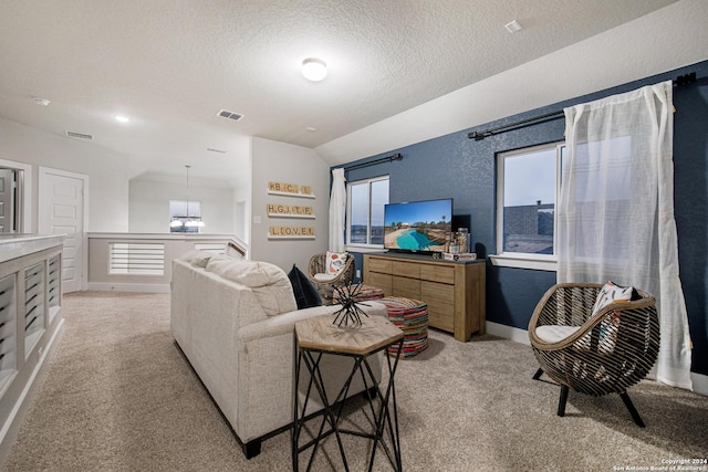 living room featuring vaulted ceiling, light colored carpet, and a textured ceiling