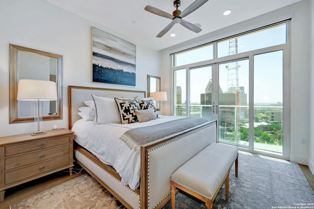 bedroom featuring access to exterior, multiple windows, light hardwood / wood-style flooring, and ceiling fan