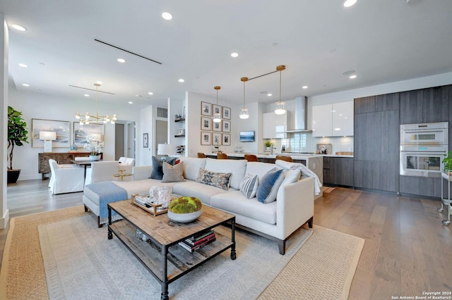 living room featuring a notable chandelier and light hardwood / wood-style flooring