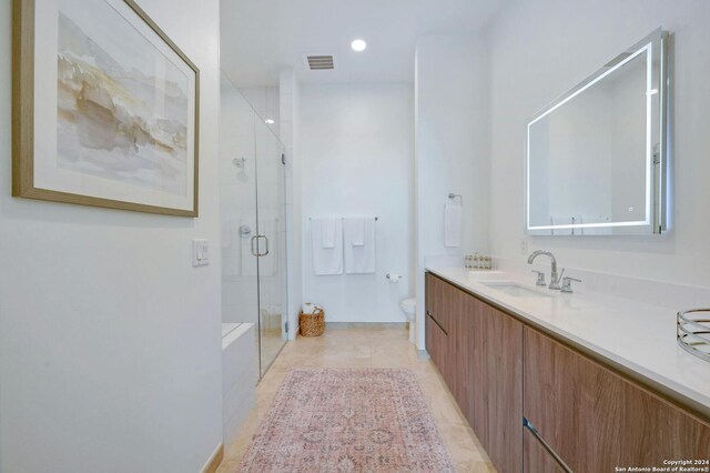 bathroom featuring tile patterned floors, toilet, vanity, and an enclosed shower