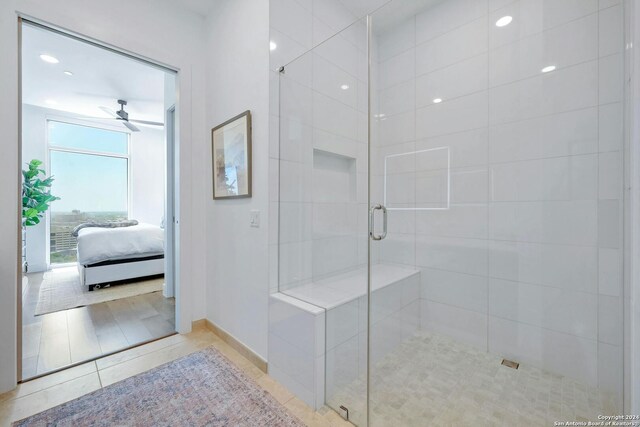 bathroom with a shower with door, ceiling fan, and tile patterned floors