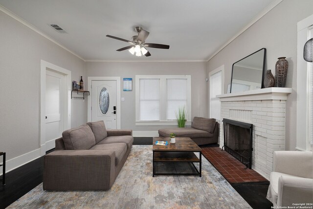 living room featuring crown molding, a brick fireplace, and wood-type flooring