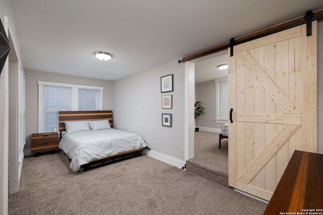 bedroom featuring carpet flooring and a barn door