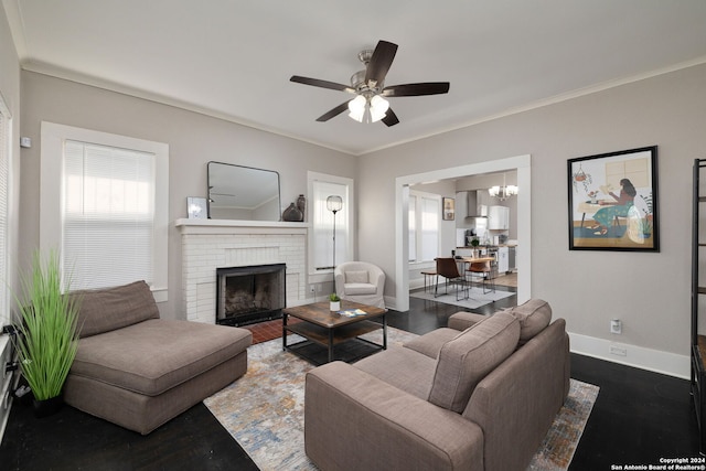 living room with crown molding, a fireplace, dark hardwood / wood-style floors, and ceiling fan with notable chandelier