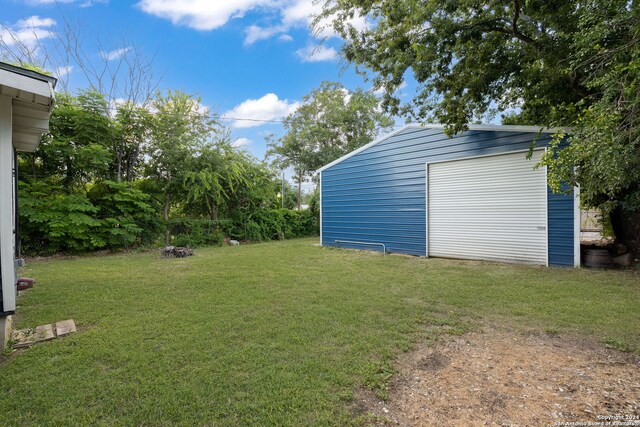 view of yard featuring a garage and an outdoor structure