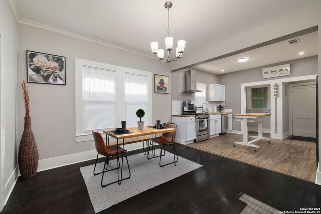 kitchen with butcher block countertops, appliances with stainless steel finishes, wall chimney range hood, white cabinetry, and dark wood-type flooring