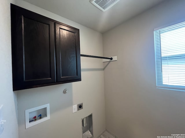 clothes washing area featuring washer hookup, hookup for an electric dryer, cabinets, and a healthy amount of sunlight