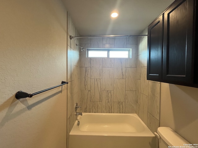 bathroom featuring tiled shower / bath combo and toilet