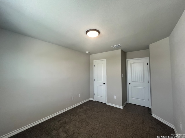 unfurnished bedroom featuring dark carpet