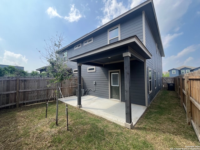 back of property featuring a lawn and a patio area