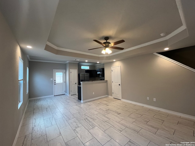 unfurnished living room featuring ceiling fan, a raised ceiling, and ornamental molding