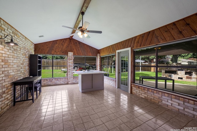 sunroom with lofted ceiling with beams and ceiling fan