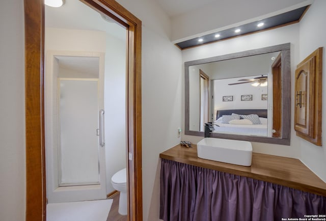 bathroom featuring an enclosed shower, vanity, toilet, and ceiling fan