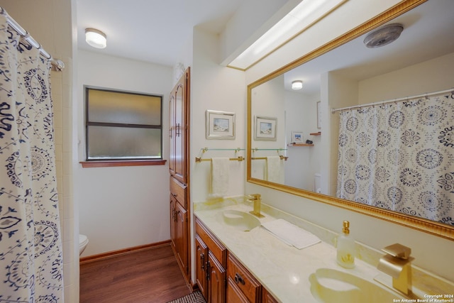 bathroom with walk in shower, vanity, toilet, and hardwood / wood-style floors