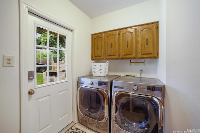 laundry area with separate washer and dryer and cabinets